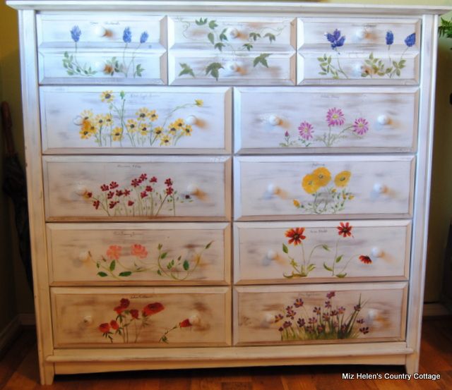 a white dresser with flowers painted on it