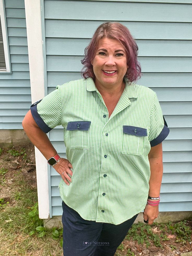 a woman standing in front of a house with her hands on her hips and smiling