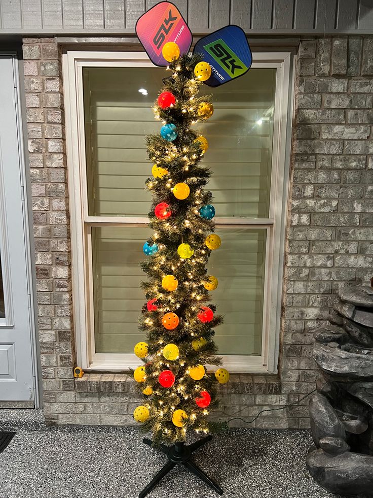 a decorated christmas tree in front of a window