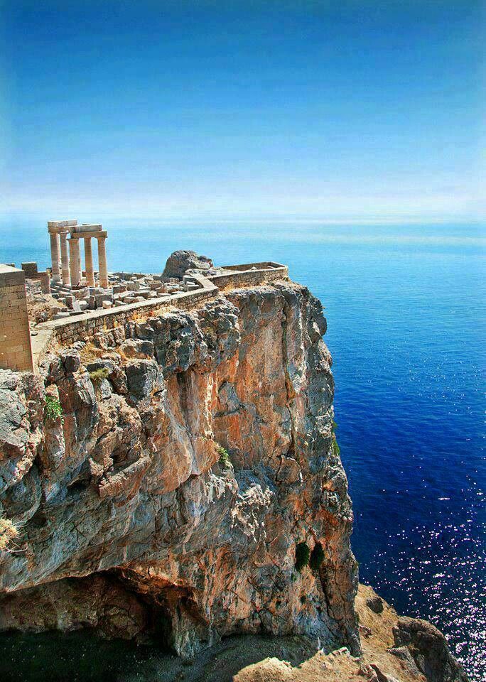 an old building sitting on top of a cliff next to the ocean