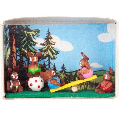 a group of teddy bears sitting on top of a wooden table next to a forest