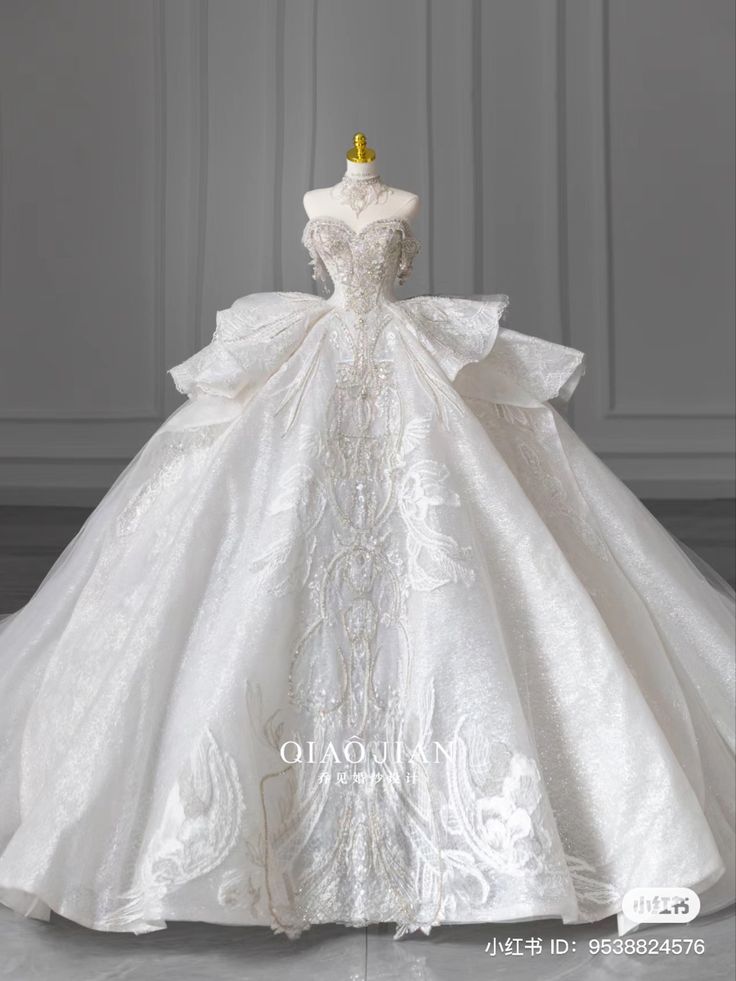 a white wedding dress on display in front of a gray background with the words miuuoao written below it