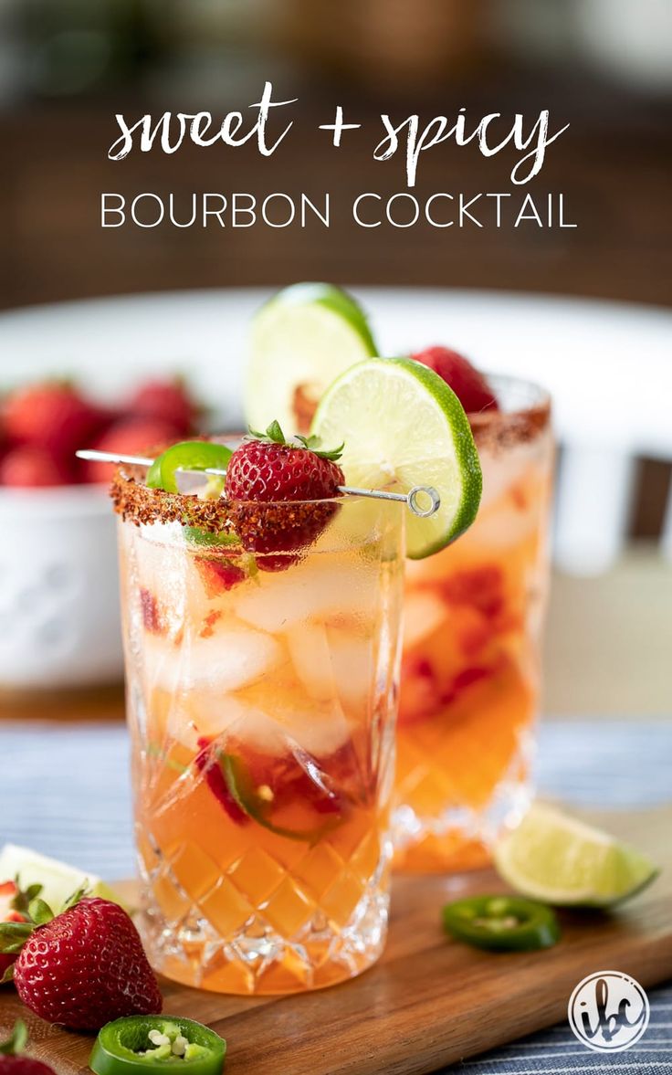 two glasses filled with ice and strawberries on top of a wooden cutting board next to limes