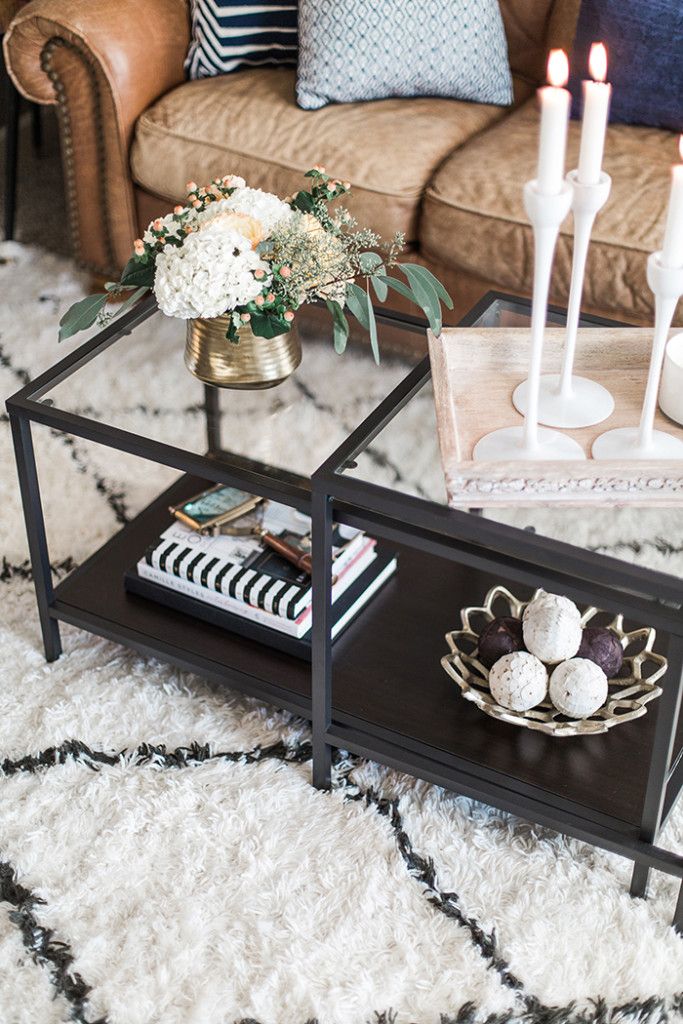 a living room with a couch, coffee table and two candles on top of it