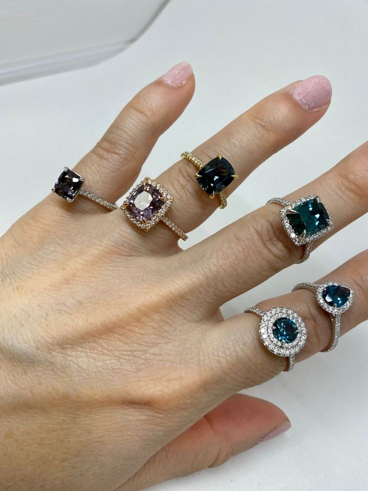 a woman's hand with five different colored rings on her left and right fingers