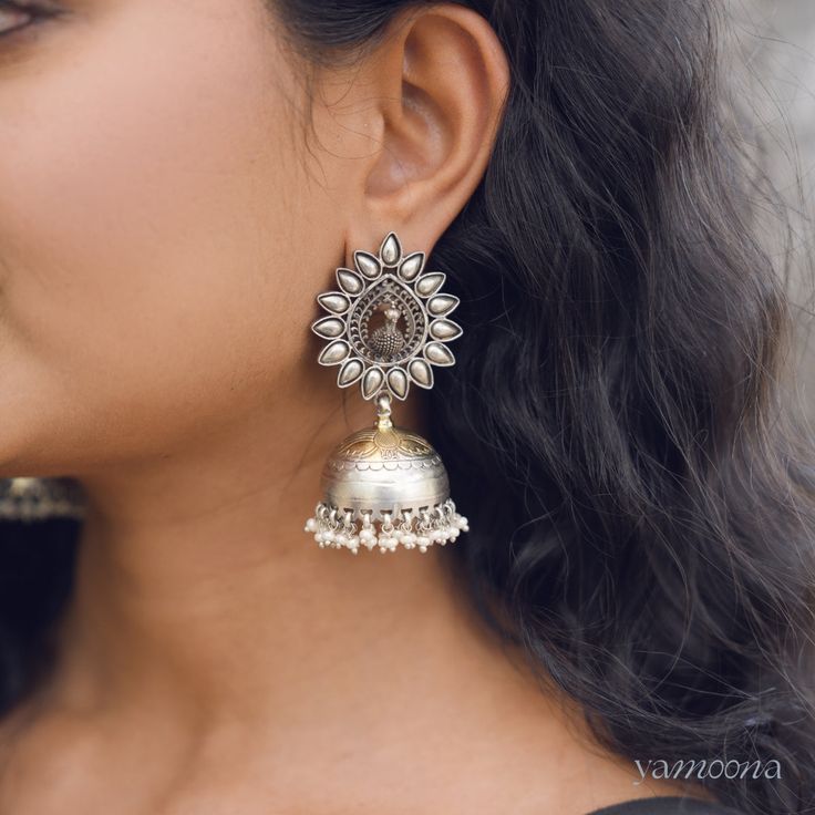 Enhance your look with Mayura jumkis, featuring an elegant oxidized finish complemented by rich 22kt gold plating. These earrings merge classic charm with a contemporary edge, offering a sophisticated accessory that stands out with every wear. Fusion Style Chandbali Brass Jhumkas, Oxidized Brass Temple Jewelry Danglers, Brass Temple Jewelry Danglers With Oxidized Finish, Temple Style Oxidized Brass Danglers, Temple Jewelry Brass Danglers With Oxidized Finish, Gold Earrings With Oxidized Finish For Festive Occasion, Festive Gold Earrings With Oxidized Finish, Festive Brass Earrings With Oxidized Finish, Elegant Brass Jhumkas With Tilla