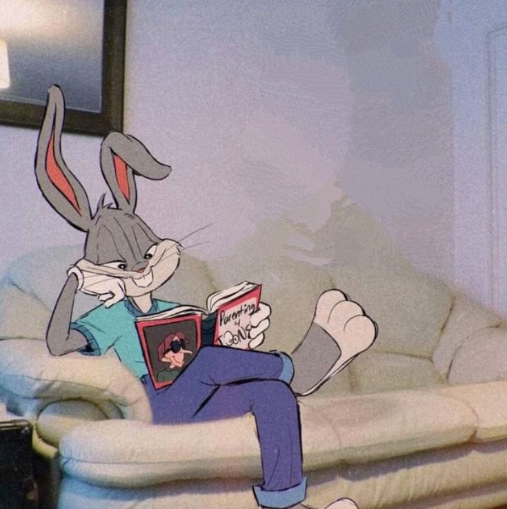 a cartoon rabbit sitting on a couch reading a book