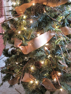 a christmas tree is decorated with ribbons and lights