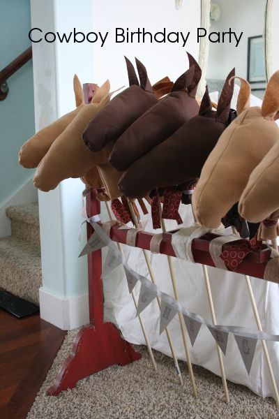 several stuffed animals are on sticks in a basket with the words cowboy birthday party written above them