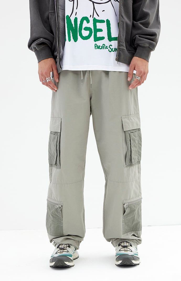 The Shadow Baggy Cargo Pants from PacSun offer a relaxed fit with wide legs, crafted from a durable cotton-nylon blend. Featuring a drawstring waistline, reinforced seams, side entry pockets, and cargo pockets with zipper details, these pants seamlessly blend practicality with contemporary style.


	Drawstring waistline
	Side pockets
	Welt back pockets
	Relaxed fit
	Cargo pockets with zip detail
	30" Inseam
	19.5" Leg opening
	Rigid
	66% Cotton, 34% nylon
	Machine washable
	Measurements taken from a size medium
	Model is wearing size medium
	Model Measurements: 6'2” Height, 30” Waist, 32” Inseam Techwear Wide Leg Parachute Pants With Patch Pockets, Streetwear Straight Parachute Pants With Patch Pockets, Utility Cargo Style Wide Leg Sweatpants, Utility Wide Leg Cargo Sweatpants, Relaxed Fit Cargo Parachute Pants, Utility Wide Leg Cargo Style Sweatpants, Green Wide Leg Parachute Pants With Patch Pockets, Streetwear Wide Leg Parachute Pants With Patch Pockets, Khaki Sweatpants With Pockets For Streetwear