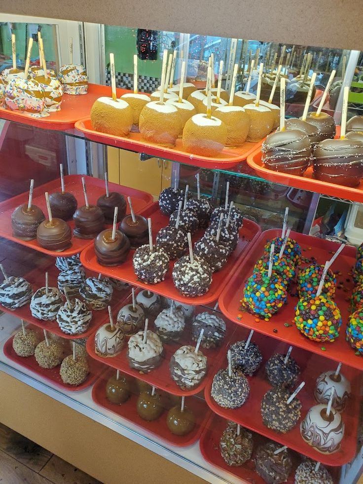 a display case filled with lots of different types of donuts and cake popss