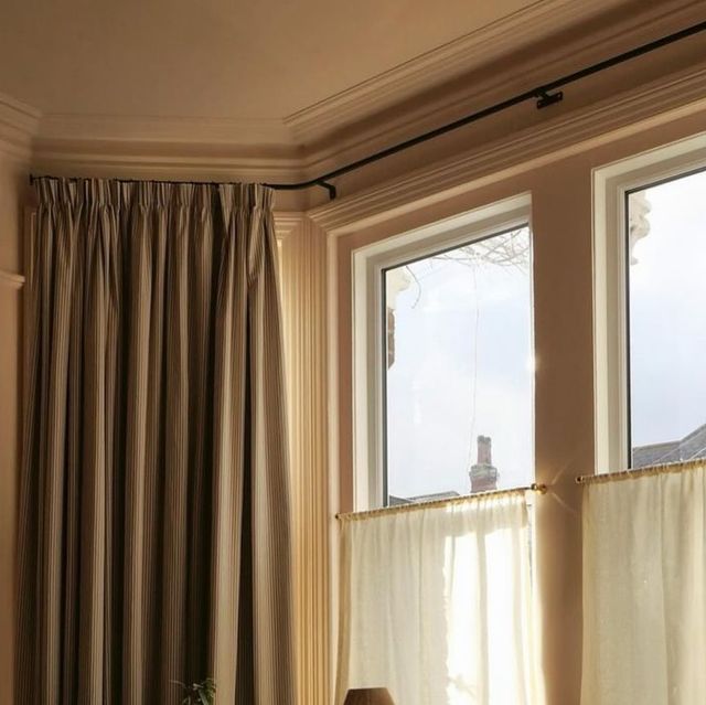 a living room with two windows and curtains