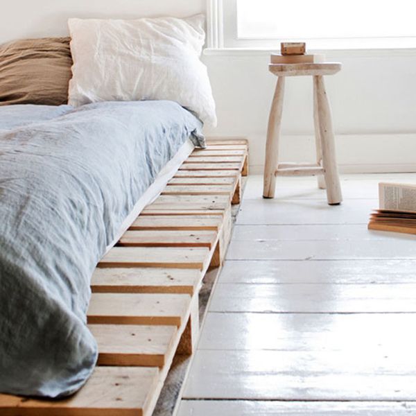 a bed sitting next to a window in a room with white walls and flooring