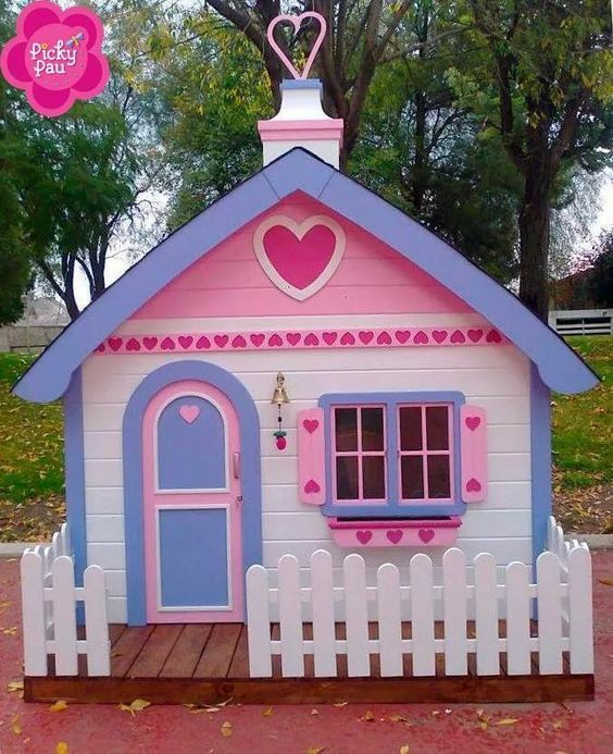 a pink and blue doll house with a heart on the roof