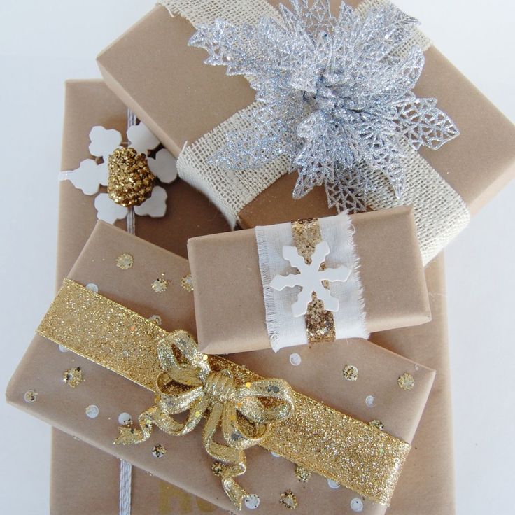 presents wrapped in brown paper with gold and white bows on them are sitting next to each other