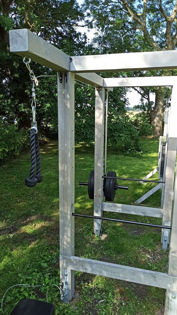 an outdoor gym in the middle of a grassy area with trees and grass behind it