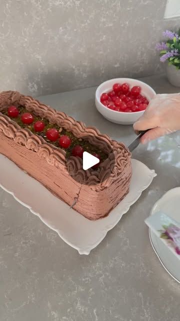 a person is cutting into a cake with cherries on the table next to it