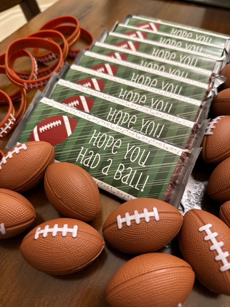 there are many footballs on the table next to each other and some candy bar wrappers