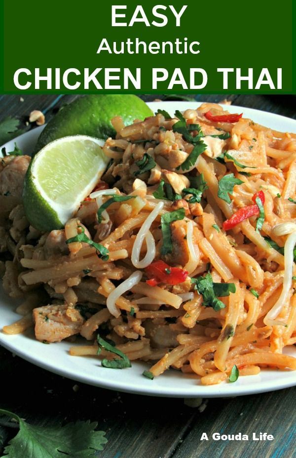 the easy authentic chicken pad thai recipe on a white plate with limes and cilantro