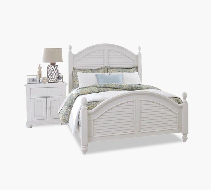 a white bed sitting next to a night stand