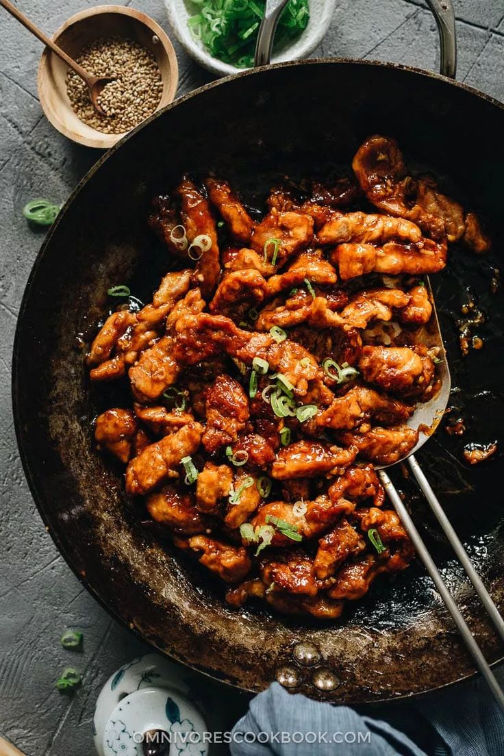 a skillet filled with chicken wings and garnished with cilantro