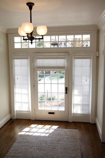 the sun shines through two windows in an empty room with wooden floors and white walls