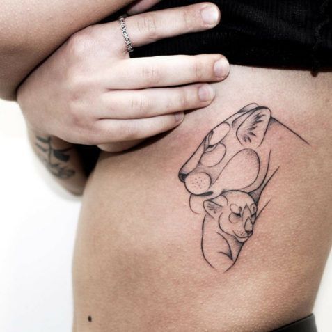 a woman's stomach with a tattoo on the side of her body and an image of a cat