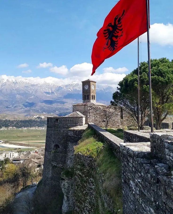 a flag flying on top of a stone wall