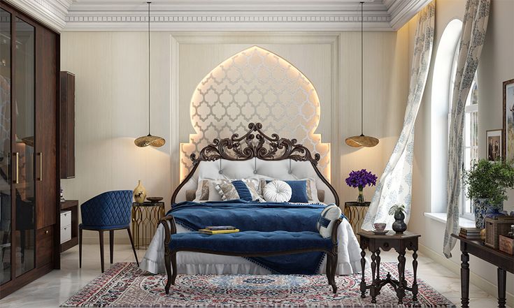 an ornately decorated bedroom with blue and white bedding, chandelier, windows, and rugs