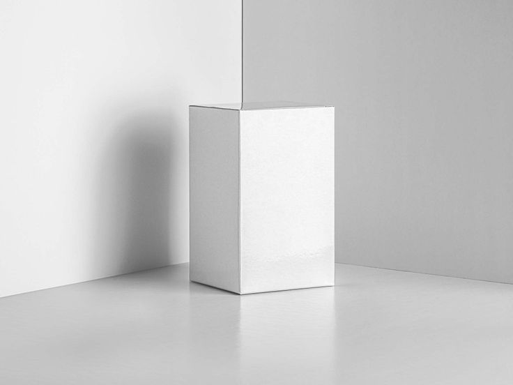 a white square object sitting on top of a floor next to a wall in an empty room