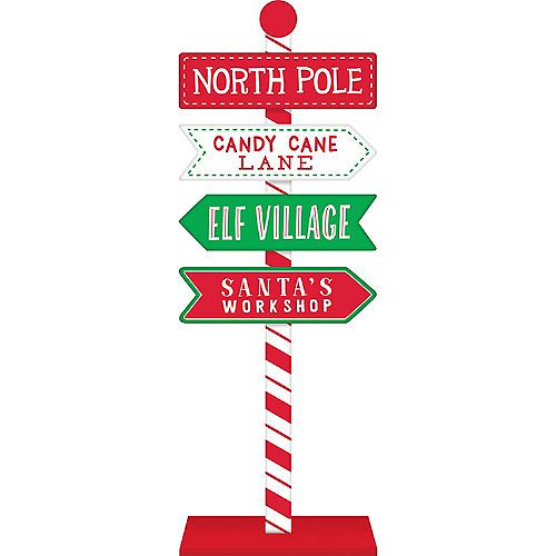 a street sign with the words north pole candy cane lane, elf village and santa's workshop