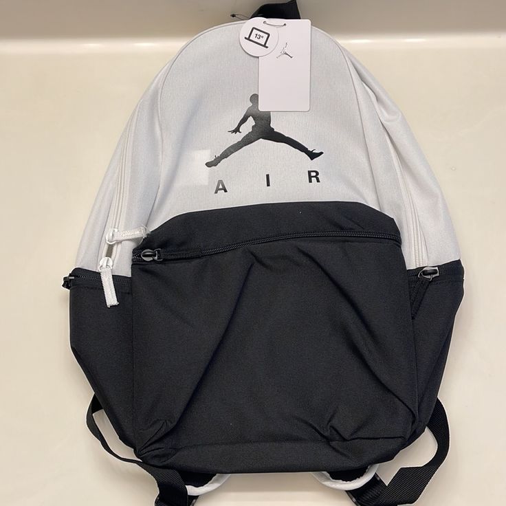 Carry All Your Gear In Iconic Style With The Jordan Air Backpack. This Premium Backpack Has All The Storage Space You Need For School, The Gym, Practices, And More. Lightweight, Durable Design. Large Front Zipper Pocket. Jumpman Air Logo. Two Side Exterior Side Pockets. Interior Laptop Sleeve. Top Haul Loop. Dual Zipper Closures On The Main Compartment. 100% Polyester. Imported. Dimensions: 17.5" H X 11.5" W X 6" D. White Sports Backpack For Back To School, White Sports Bag For Back To School, White Zipper Closure Bag For Streetwear, Sporty School Bags With Logo, Sporty White Backpack For Daily Use, Sporty White Backpack, Casual White Bag With Logo, Casual White Bags With Logo, Back To School Standard Backpack With Logo