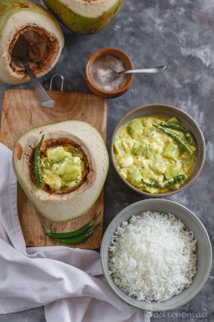 an avocado is cut in half on a cutting board next to some rice