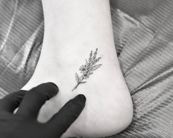 a woman's foot with a flower tattoo on it