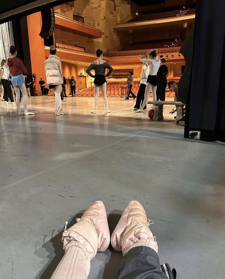 a person laying on the floor with their feet up in front of them and people standing around