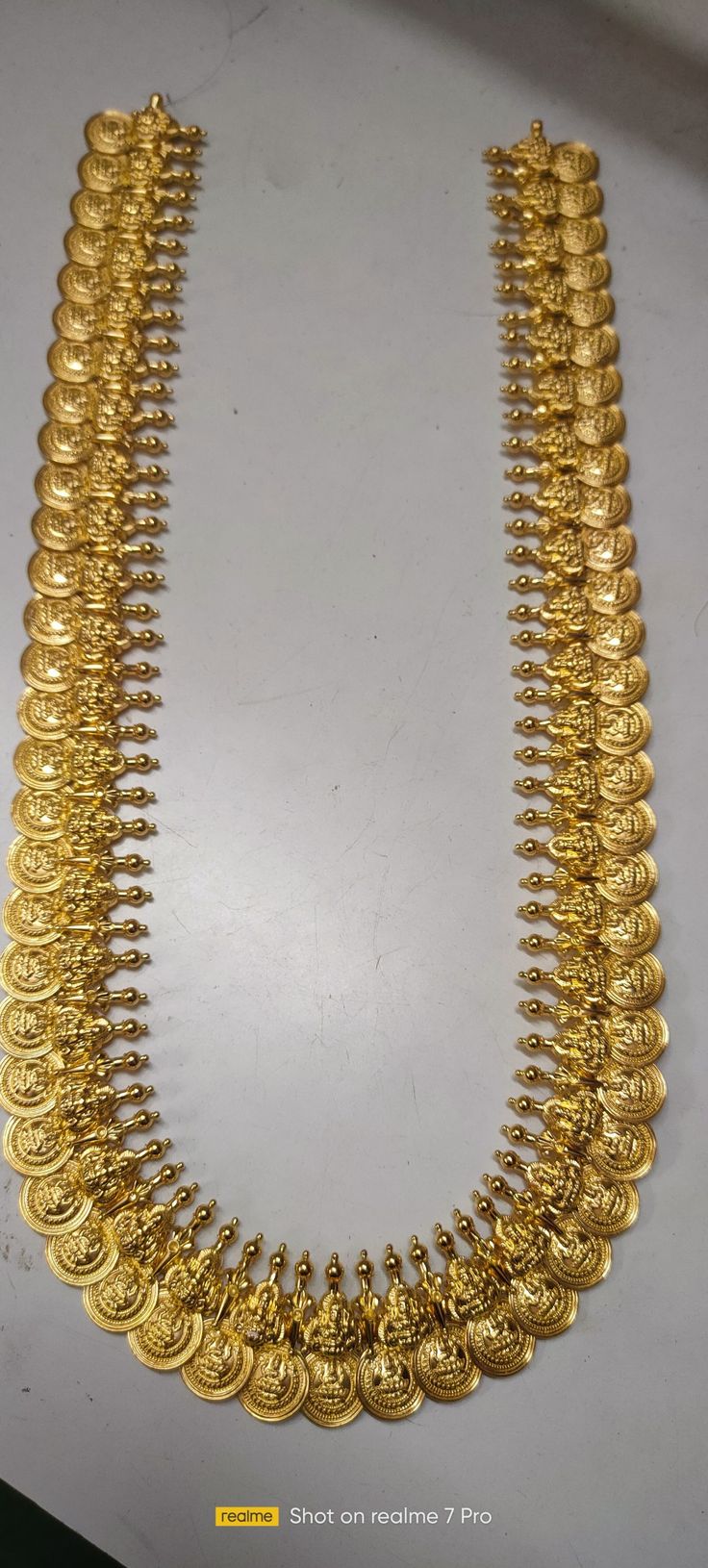 a gold necklace is displayed on a table