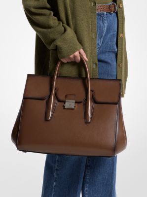 Crafted in Italy from burnished calf leather, the streamlined Campbell weekender bag is a study in sophistication. Elegant lock hardware opens to a luxuriously roomy interior lined in goat suede, while interior slip pockets keep your essentials at arm’s reach. Finished with comfortable and superbly made top handles, this bag ensures you always travel in style. Timeless Brown Satchel With Branded Hardware, Timeless Office Satchel With Turn-lock Closure, Brown Briefcase With Gold-tone Hardware For Work, Rectangular Office Briefcase With Branded Hardware, Classic Office Bags With Branded Hardware, Classic Office Bag With Branded Hardware, Modern Business Briefcase With Branded Hardware, Office Bags With Turn-lock Closure In Calf Leather, Office Satchel With Branded Hardware