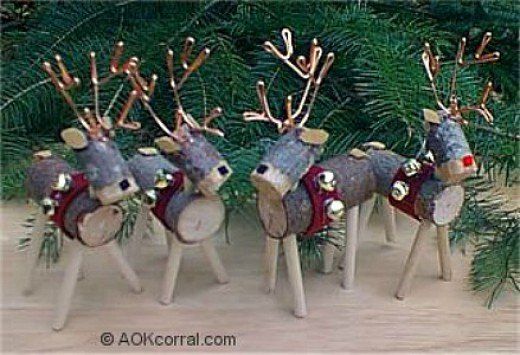 four reindeer figurines are standing in front of some pine branches and evergreens