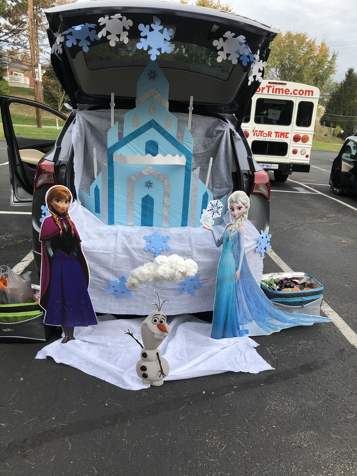 the trunk of a car is decorated with frozen princess figures and snowmen in front of it