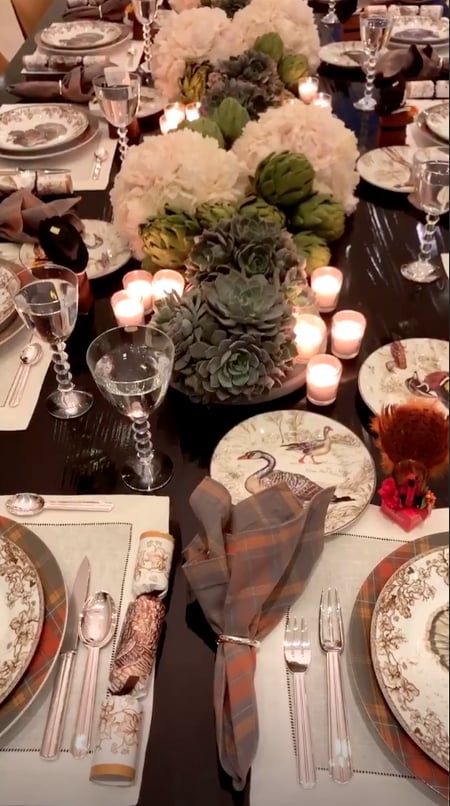 the table is set with plates, silverware and candles for an elegant dinner party