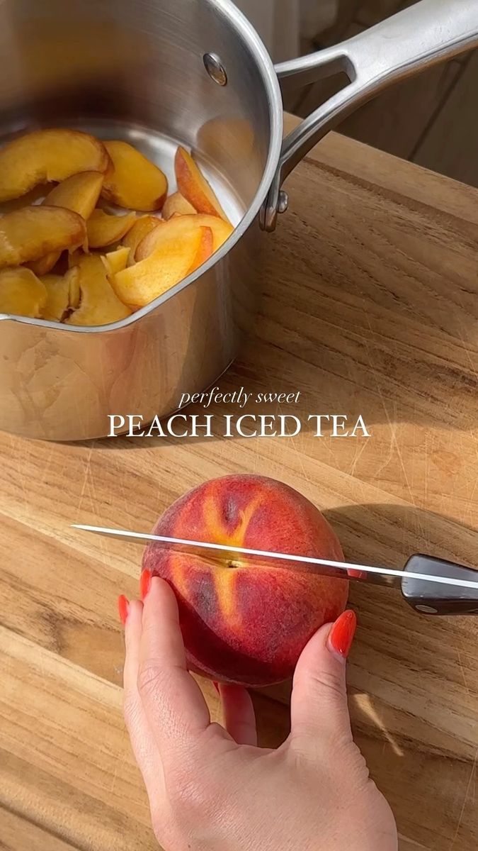 a person is cutting up peaches on a wooden table with a metal pot and tongs