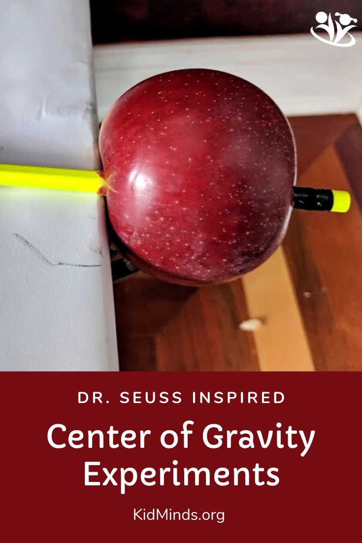 a red apple sitting on top of a wooden floor next to a yellow marker and the words center of gravity experiments