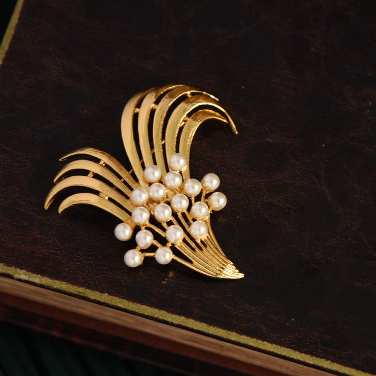 This stunning Gold Bouquet Brooch is the perfect way to show your love and appreciation. Featuring an elegant pearl brooch and intricate art deco design, this beautiful gift is ideal for both men and women, perfect for weddings, anniversaries, and beyond! Make a lasting impression and give the perfect gift today! 👌 M A T E R I A L • 18K Gold plated over brass• Faux pearls• This product is hypoallergenic (nickel free) and tarnish resistant 📏 S I Z E • Length: 6.6 cm (2.6 inch)• Width: 6.2 cm (2 Elegant Pearl Brooches For Formal Occasions, Elegant Brooches For Vintage Events, Elegant Pearl Brooches For Evening, Elegant Evening Pearl Brooches, Elegant Brooch Pins For Vintage Events, Gold Pearl Brooches For Wedding, Elegant Vintage Brooch Pins, Formal Gold Pearl Brooches, Elegant Gold Pins