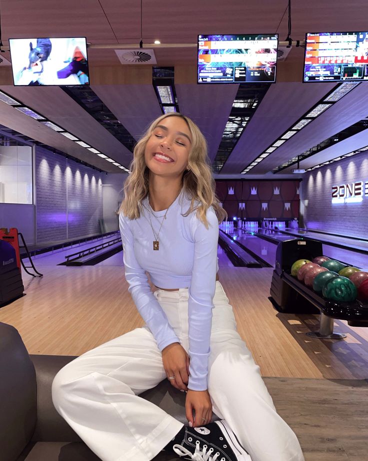 a woman sitting on top of a bowling alley