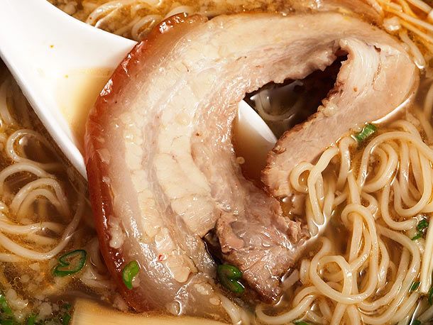 a bowl filled with meat and noodles on top of a table