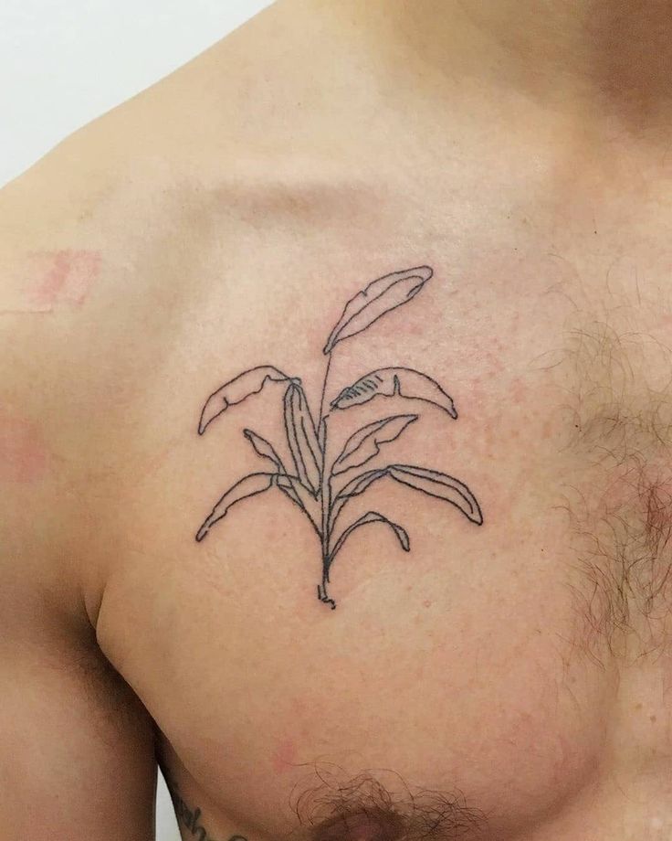 a close up of a man's chest with a flower tattoo on it