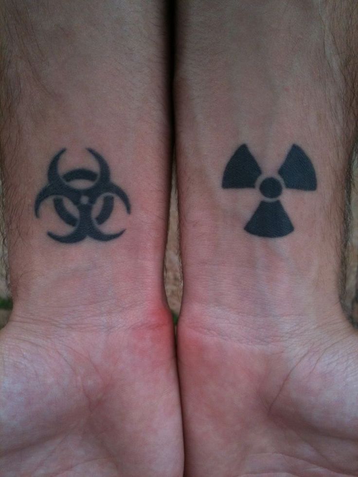 two people with matching tattoos on their arms, both have biohazard symbols tattooed on them