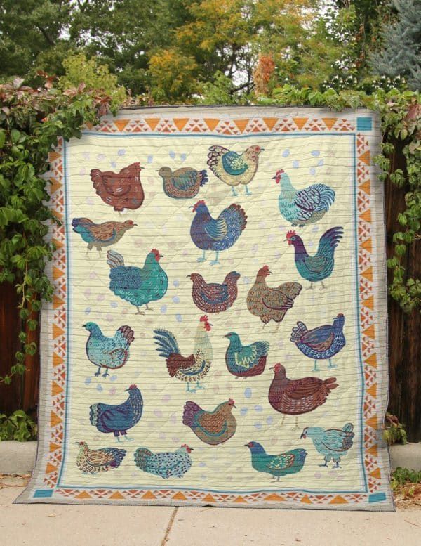 a quilt with chickens on it in front of a fence