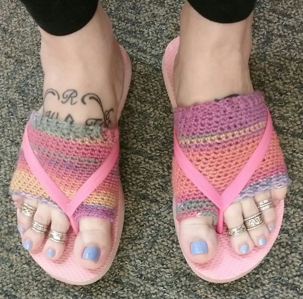 a woman's feet with colorful sandals and tattoos