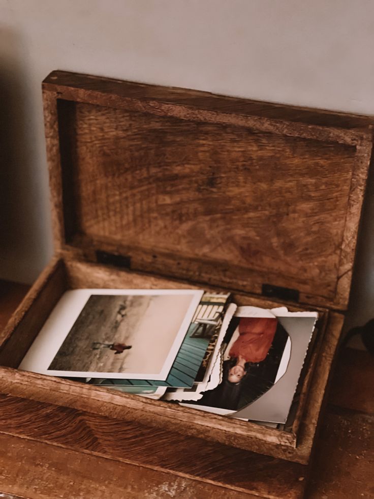 an open wooden box with photos inside